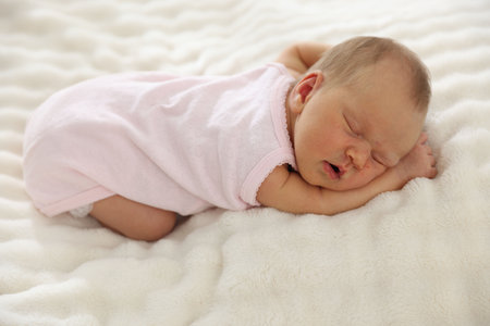 Cute newborn baby sleeping on bed indoorsの写真素材