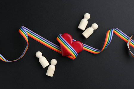 Tolerance concept. Human figures, heart and colorful ribbon on black background, flat layの写真素材