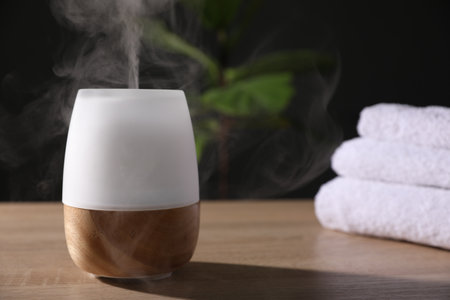 Modern aroma lamp on wooden table indoorsの写真素材