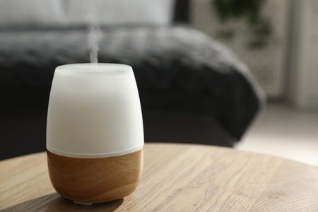 Modern aroma lamp on wooden table indoors, closeup. Space for textの写真素材