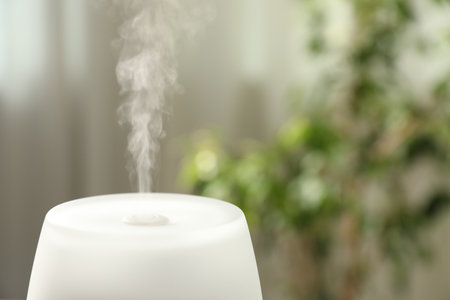 Modern aroma lamp against blurred background, closeup. Space for textの写真素材