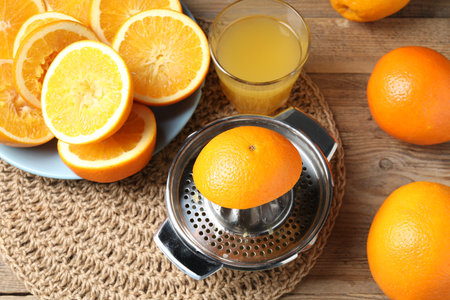 Freshly squeezed orange juice, fruits and juicer on wooden table, above viewの写真素材