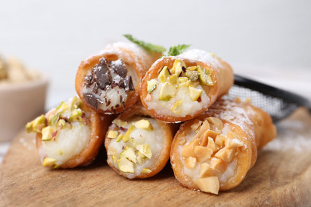 Delicious cannoli with nuts, powdered sugar, chocolate and mint on table, closeupの写真素材