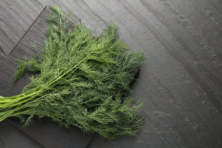 Bunch of fresh dill on black table, top view. Space for textの写真素材