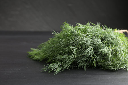 Bunch of fresh dill on black table, closeup. Space for textの写真素材