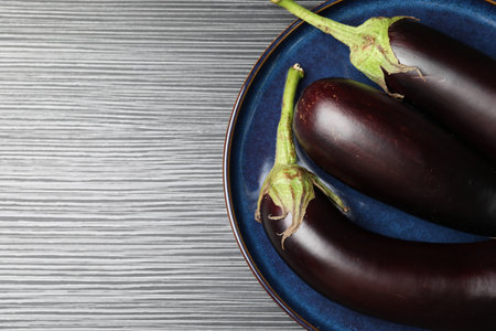 Many ripe eggplants on black wooden table, top view.の写真素材