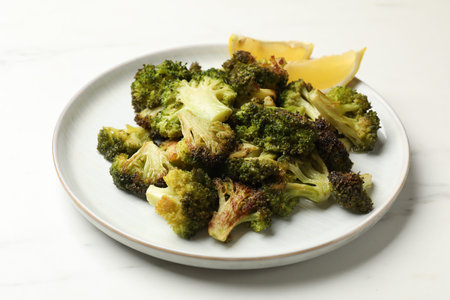 Tasty fried broccoli and lemon on white marble table, closeupの写真素材