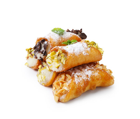 Delicious cannoli with cheese, nuts, powdered sugar, chocolate and mint isolated on whiteの写真素材