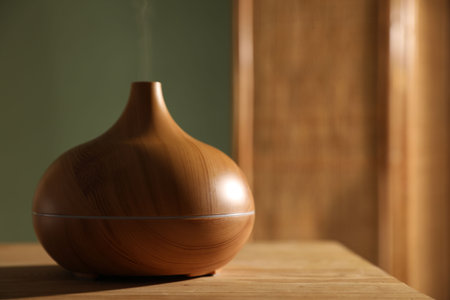 One stylish aroma lamp on wooden table indoors, closeup. Space for textの写真素材