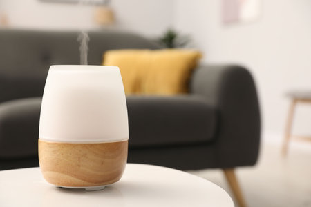 Modern aroma lamp on white table indoors. Space for text