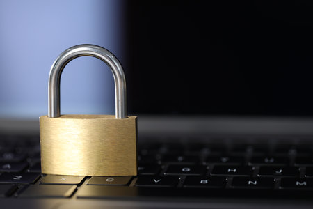 Cyber safety. Metal padlock on laptop, closeup. Space for textの写真素材