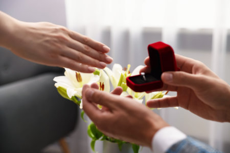 Man with engagement ring making marriage proposal to his girlfriend indoors, closeup