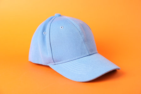 One light blue baseball cap on orange background, closeup. Mockup for designの写真素材