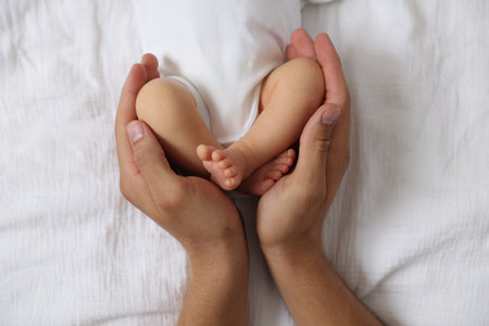 Father with his cute newborn baby on bed, top viewの写真素材