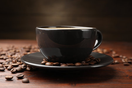 Aromatic coffee in cup and beans on wooden table, closeupの写真素材
