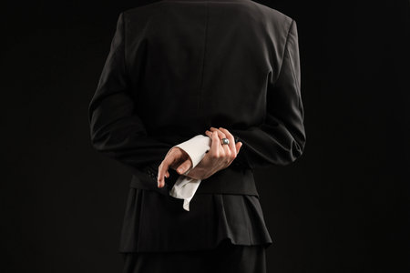 Young man wearing stylish suit and ring on black background, closeupの写真素材