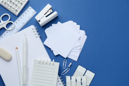 White stationery on blue background, flat lay. Space for textの写真素材