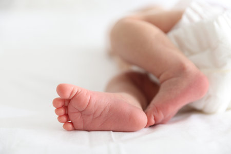 Cute newborn baby lying on bed, closeupの写真素材