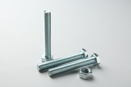 Metal bolts and nut on white background, closeup. Hardware tool