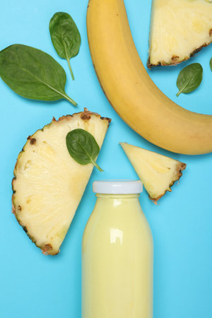 Superfood. Tasty smoothie in glass bottle and ingredients on light blue background, flat layの写真素材