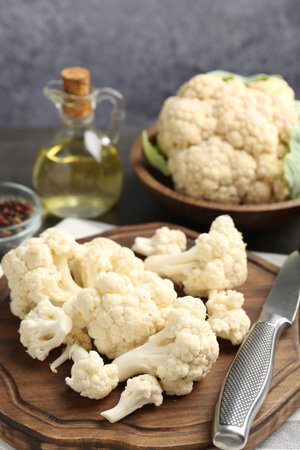 Fresh raw cauliflower florets, spices and knife on table, closeupの写真素材