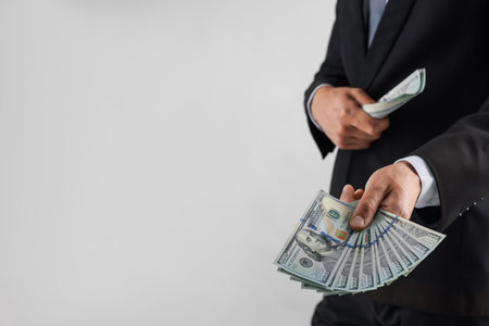 Man with dollar bills on light background, closeup. Space for text