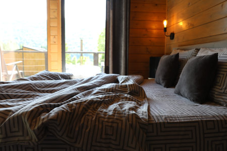 Comfortable bed near window in hotel room