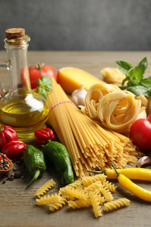 Different types of pasta and ingredients on wooden table, closeupの写真素材