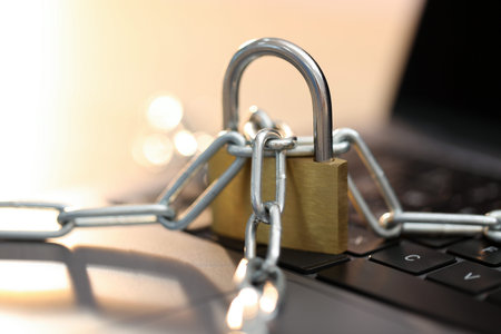 Cyber safety. Metal padlock with chain on laptop, closeup