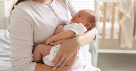 Mom with her newborn baby at home, closeup