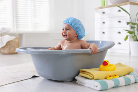 Cute little baby in cap bathing at home