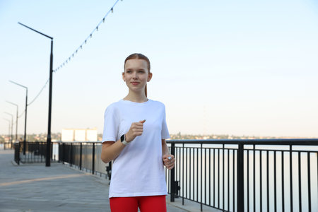 Beautiful teenage girl jogging outdoors. Morning runの写真素材