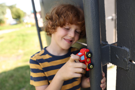 Little boy playing with toy car outdoors, selective focusの写真素材
