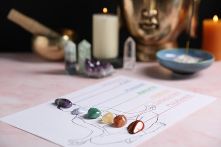Human drawing with gemstones placed on chakras on light pink table, closeupの写真素材
