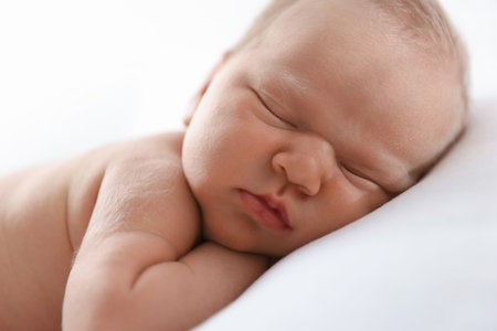 Cute newborn baby sleeping on pillow indoors