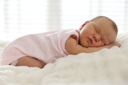 Cute newborn baby sleeping on bed indoorsの写真素材