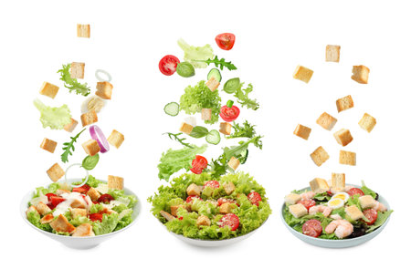 Croutons and other ingredients falling into bowls of salads against white background, setの写真素材