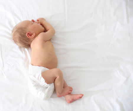 Cute newborn baby sleeping on bed, top view. Space for textの写真素材
