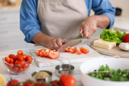 Senior woman cooking at white marble table in kitchen, closeupの写真素材