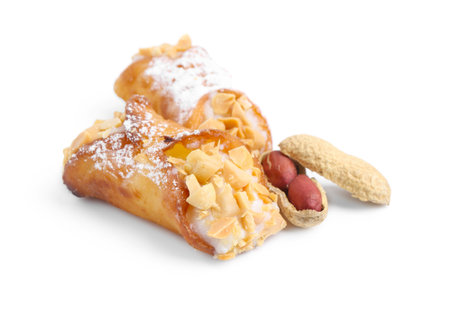 Delicious cannoli with ricotta cheese, peanuts and powdered sugar isolated on whiteの写真素材
