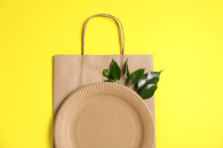 Different eco friendly packaging and leaves on yellow background, flat layの写真素材