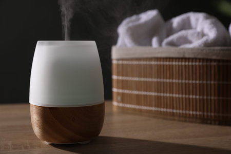 Modern aroma lamp on wooden table indoors