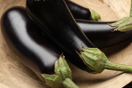 Whole fresh eggplants in wooden bowl, closeupの写真素材