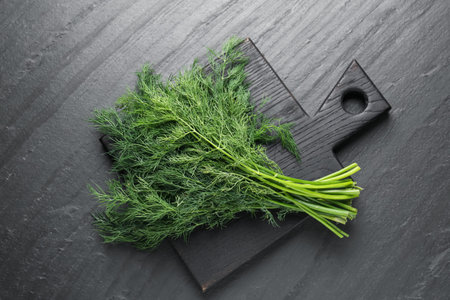 Bunch of fresh dill on black table, top viewの写真素材