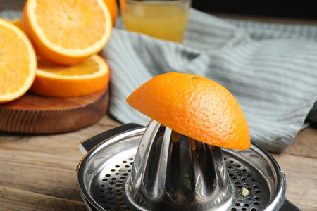 Squeezer and oranges on wooden table, closeup. Making fresh juiceの写真素材