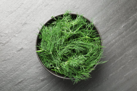 Fresh dill in bowl on black table, top viewの写真素材