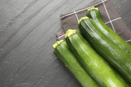 Fresh ripe zucchinis on black table, top view. Space for textの写真素材