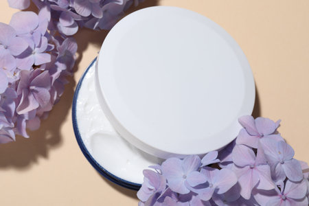 Cosmetic product and flowers on beige background, flat lay. Mockup for designの写真素材