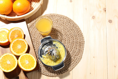 Freshly squeezed orange juice, fruits and juicer on wooden table, flat lay. Space for text