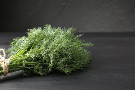 Bunch of fresh dill on black table, closeup. Space for textの写真素材